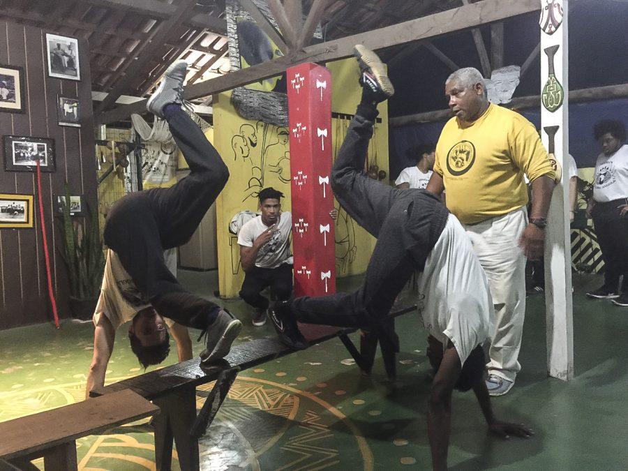 From left to right, College senior Davíd Zager and College junior Deron Essex receive instruction in Capoeira Angola from Mestre Jurandir of the International Capoeira Angola Foundation. Capoeira is a martial art and dance form developed by Angolans in Brazil in the 16th century. The art form is practiced in countries all over the world, and made its way to the U.S. in the late 20th century. 

Several students took part in the trip to Brazil over Winter Term, led by Associate Professor of Theater and Africana Studies Justin Emeka, OC ’95. Students spent 20 days in the cities of Belo Horizonte and Salvador, working with three different Capoeira groups and participating in a facilitated discussion on how the art can be used to face racial divides and inequality in the U.S. 
